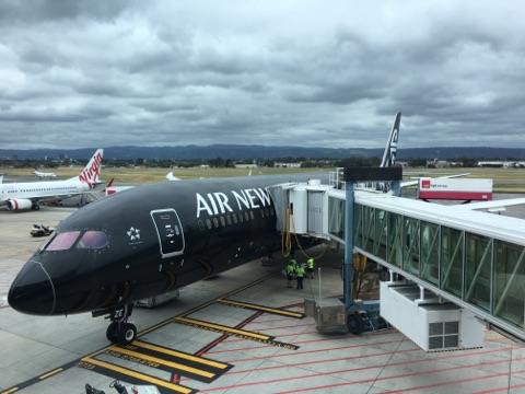 Air New Zealand Dreamliner 787-9 parked at the gate while storm clouds loom in the distance